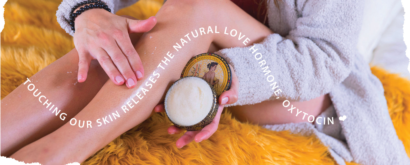 Person applying essential oil muscle rub to their leg with text 'Touching our skin releases natural love hormone, oxytocin' with a yellow carpet.