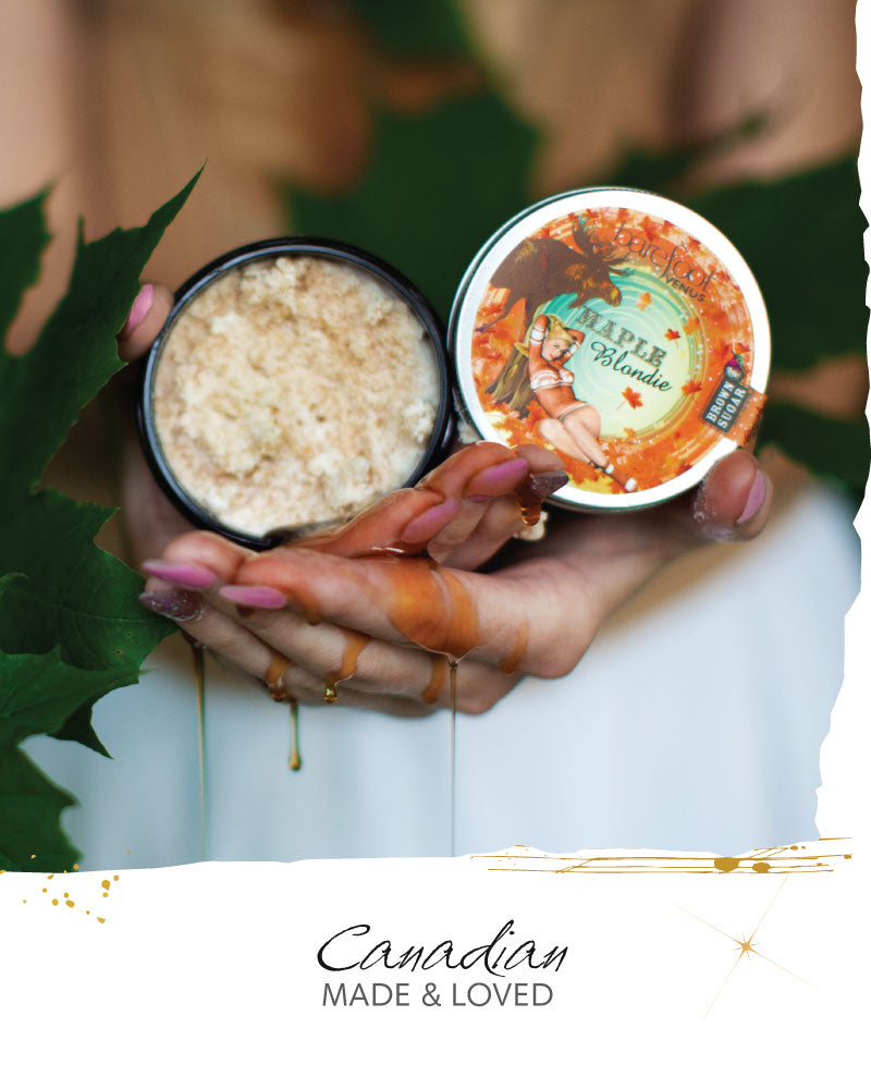 Container of sugar scrub held by hands with a blurred background, featuring 'Canadian Made & Loved'
